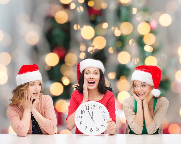 微笑的妇女，在圣诞老人的助手帽子与时钟 — 图库照片