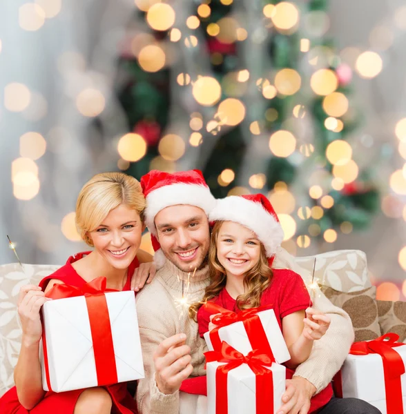 Família feliz em santa helper chapéus com caixas de presente — Fotografia de Stock