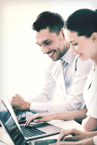 Hombre y mujer trabajando con el ordenador portátil en la oficina — Foto de Stock