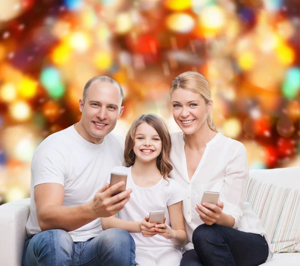 Familia feliz con smartphones — Foto de Stock