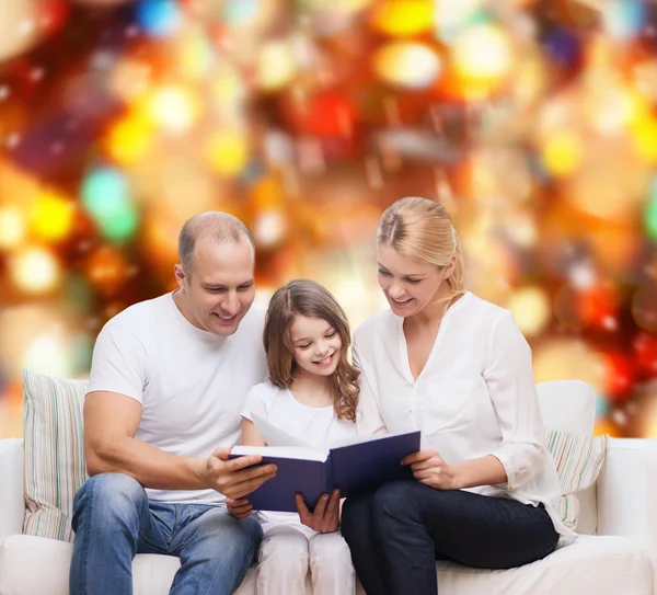 Família feliz com livro em casa — Fotografia de Stock