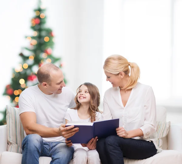 Familia feliz con libro en casa — Foto de Stock