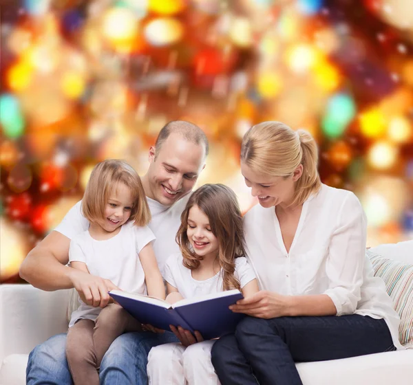 Famille heureuse avec livre à la maison — Photo