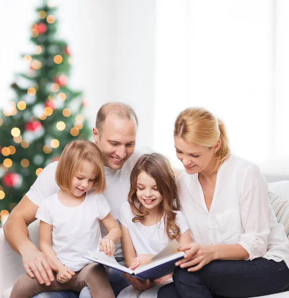 Família feliz com livro em casa — Fotografia de Stock