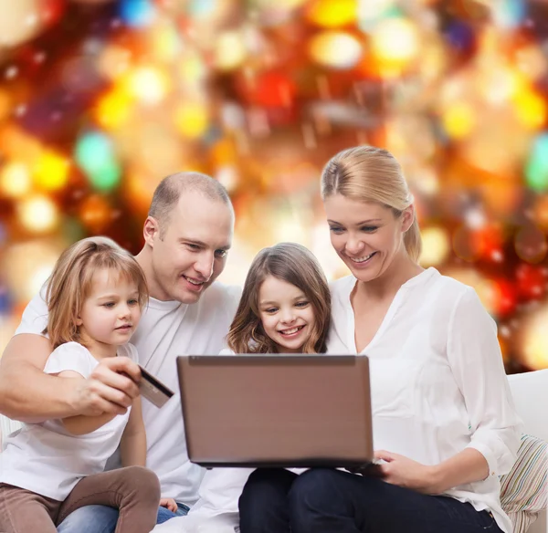 Familia feliz con ordenador portátil y tarjeta de crédito —  Fotos de Stock