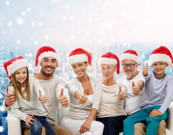 Mutlu bir aile içinde başparmak gösterilen santa şapkalar — Stok fotoğraf