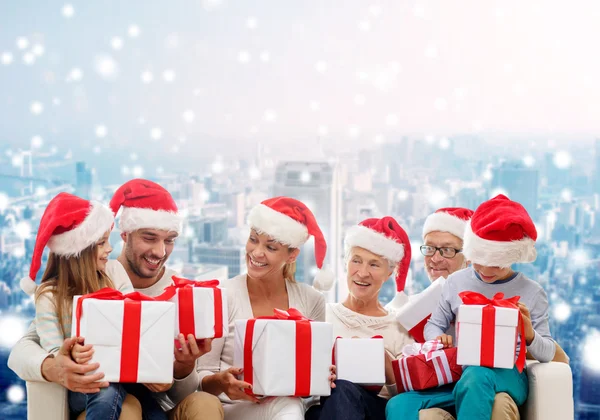 Happy family in santa helper hats with gift boxes — Stock Photo, Image