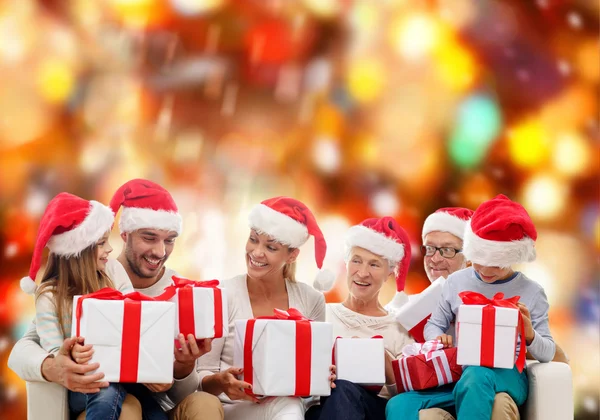 Família feliz em santa helper chapéus com caixas de presente — Fotografia de Stock