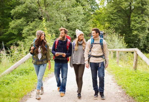 Groep vrienden met rugzakken en tablet pc — Stockfoto