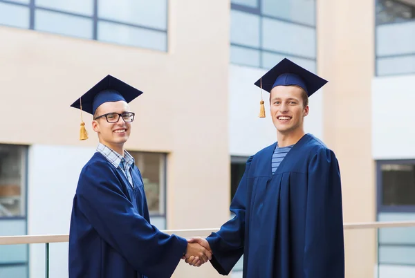 Usmívající se studenti v mortarboards — Stock fotografie