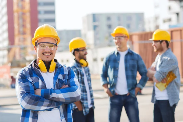 Ομάδα των χαμογελαστά οικοδόμων στο hardhats υπαίθρια — Φωτογραφία Αρχείου