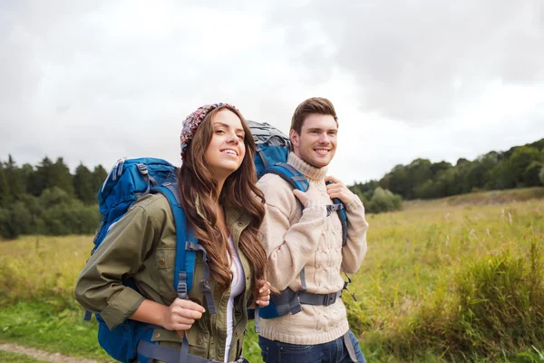 Lachende paar met rugzakken wandelen — Stockfoto