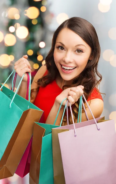 Mulher sorridente com sacos de compras coloridos — Fotografia de Stock