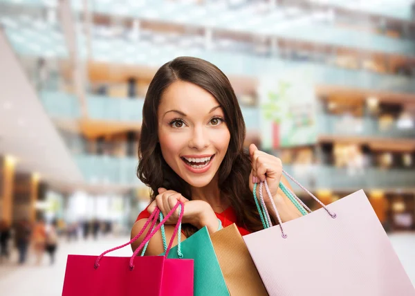 Mulher sorridente com sacos de compras coloridos — Fotografia de Stock