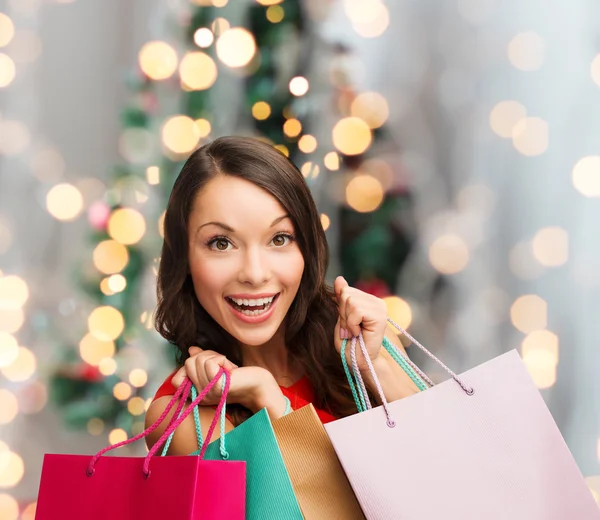 Mulher sorridente com sacos de compras coloridos — Fotografia de Stock