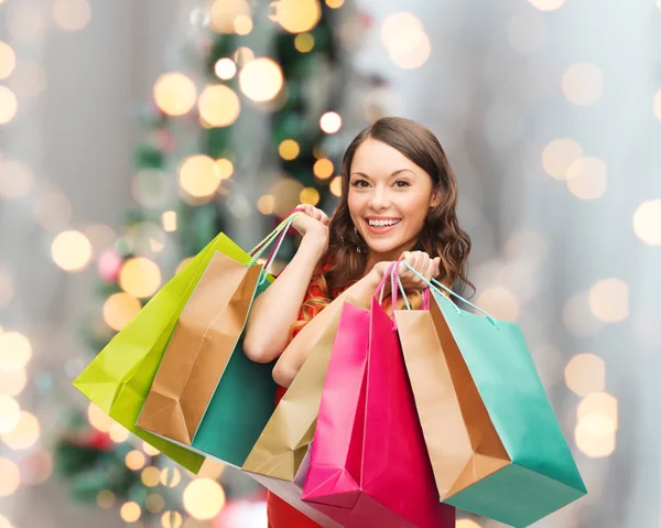 Mulher sorridente com sacos de compras coloridos — Fotografia de Stock