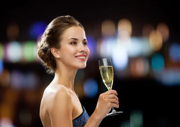 Sonriente mujer sosteniendo un vaso de vino espumoso —  Fotos de Stock