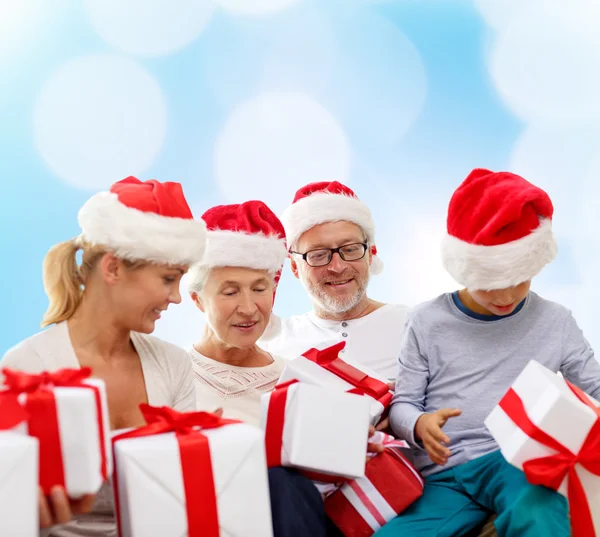 Famiglia felice in cappelli Babbo Natale aiutante con scatole regalo — Foto Stock