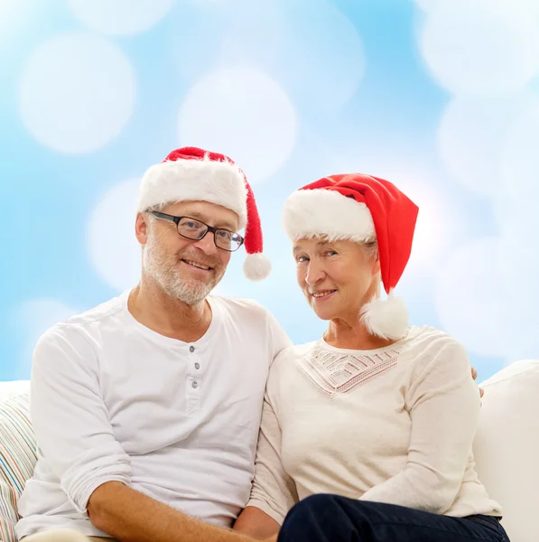 Happy senior couple in santa helper hats — Stock Photo, Image