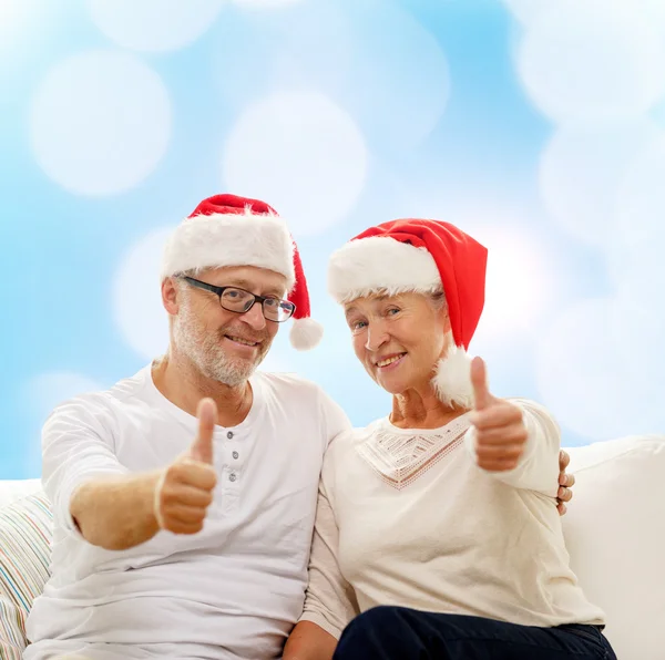 Happy senior couple in santa helper hats — Stock Photo, Image