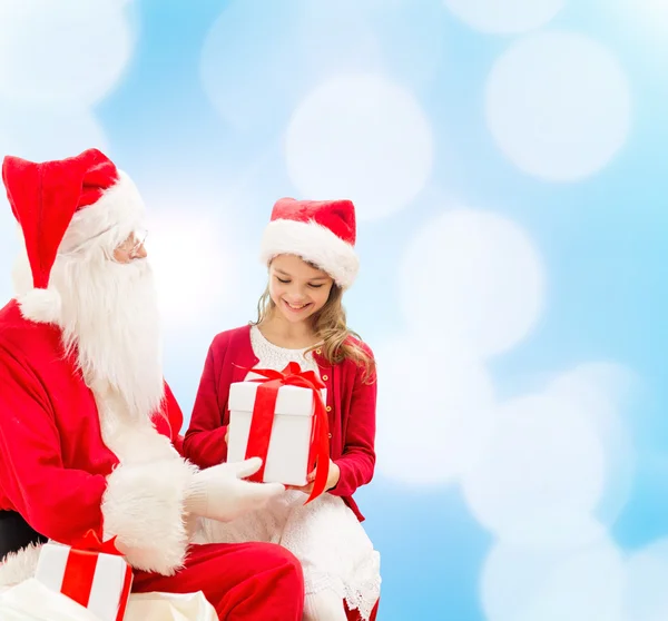 Niña sonriente con santa claus y regalos —  Fotos de Stock