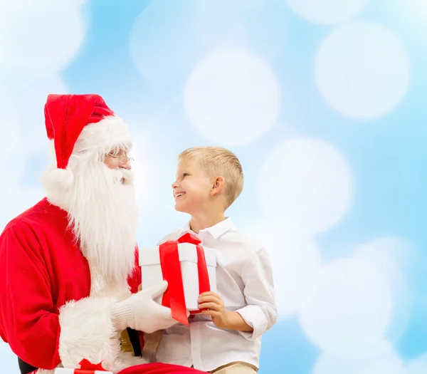 Smiling little boy with santa claus and gifts Stock Image