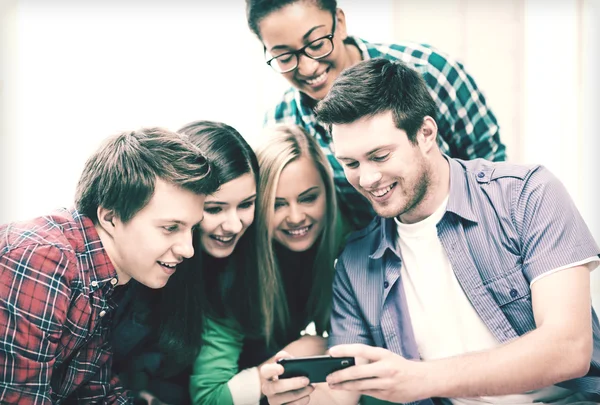 Studenti che guardano smartphone a scuola — Foto Stock