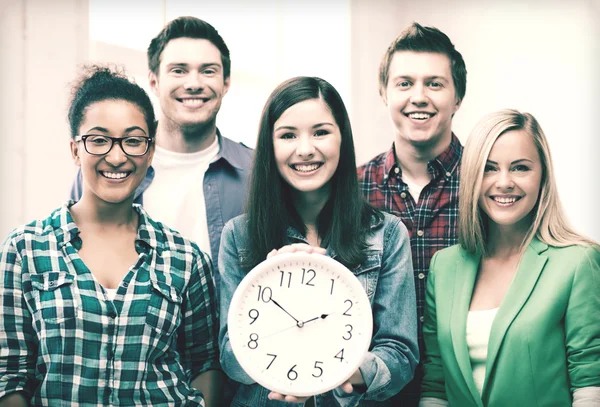 Gruppo di studenti a scuola con orologio — Foto Stock