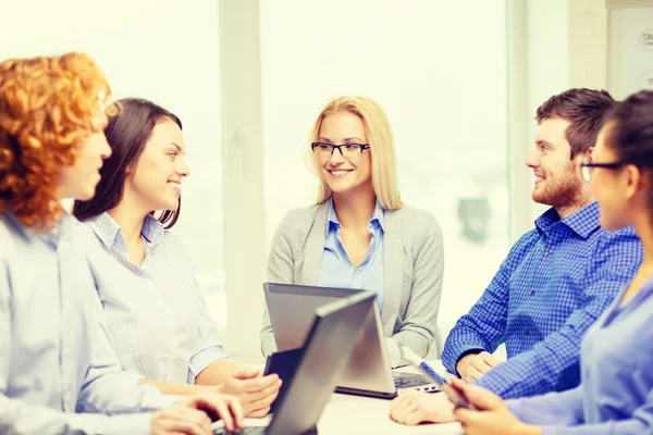 Equipo sonriente con computadoras portátiles y de mesa PC —  Fotos de Stock