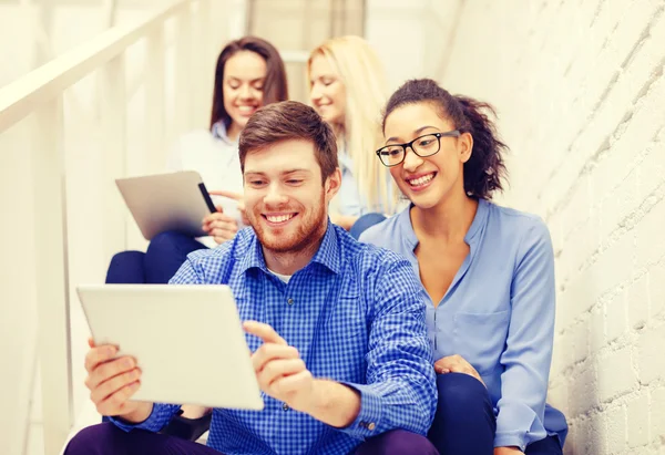 Team with tablet pc computer sitting on staircase — Stock Photo, Image