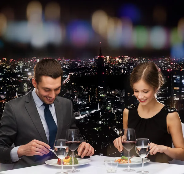 Smiling couple eating main course at restaurant — Stock Photo, Image