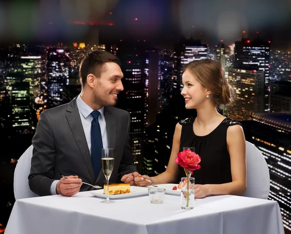 Smiling couple eating dessert at restaurant — Stock Photo, Image