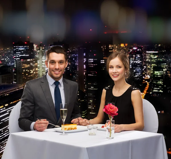 Smiling couple eating dessert at restaurant — Stock Photo, Image