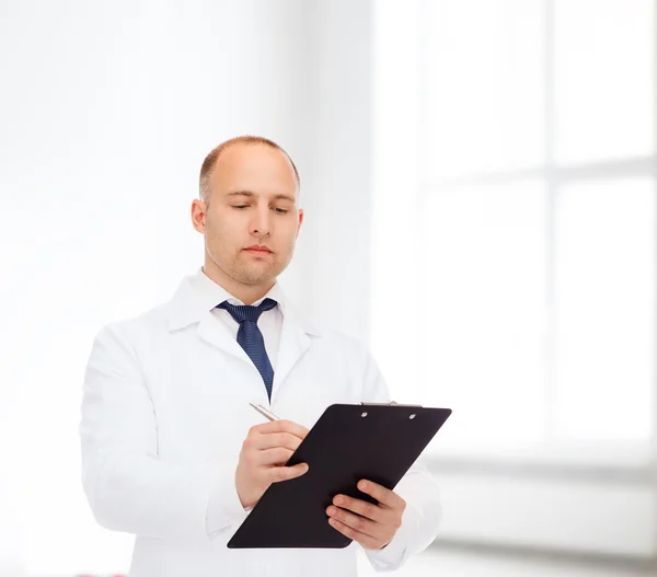 Médecin masculin sérieux avec presse-papiers — Photo