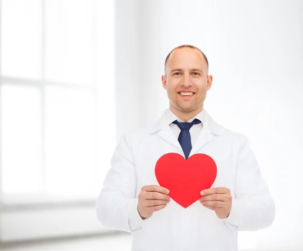 Sonriente médico varón con corazón rojo — Foto de Stock