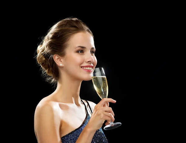 Lachende vrouw bedrijf glas mousserende wijn — Stockfoto