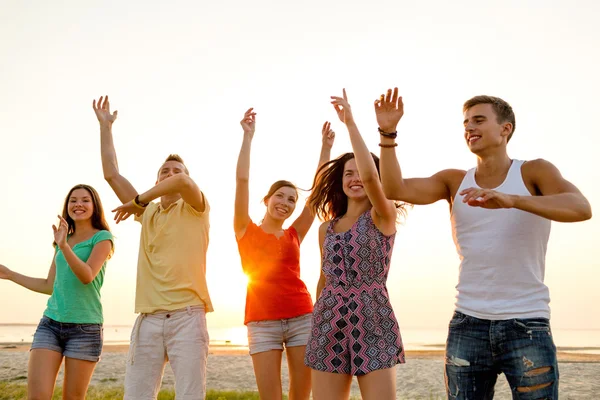 Amigos sonrientes bailando en la playa de verano — Foto de Stock