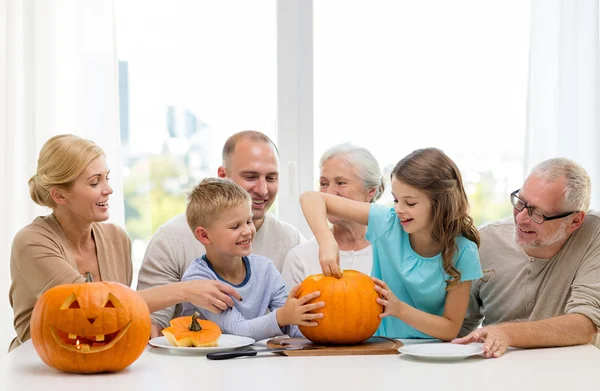 Happy family sitting with pumpkins at home — Stock Photo, Image