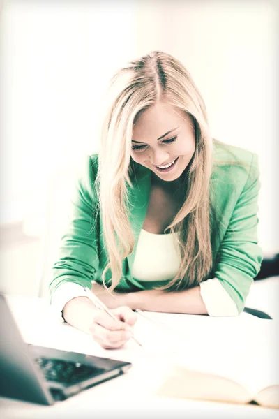 Estudante sorridente escrevendo em caderno — Fotografia de Stock