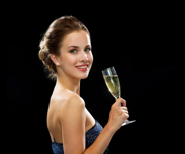 Sonriente mujer sosteniendo un vaso de vino espumoso — Foto de Stock