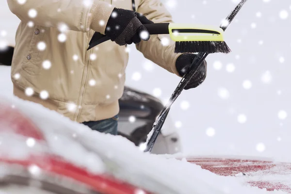 Närbild av man rengöra snö från bilen — Stockfoto