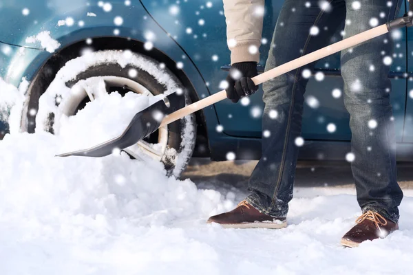 男人用附近车铲挖雪的特写 — 图库照片