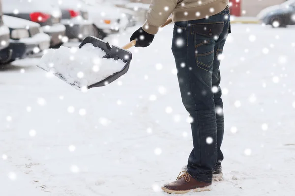 Nahaufnahme eines Mannes, der mit Schaufel neben Auto Schnee schaufelt — Stockfoto