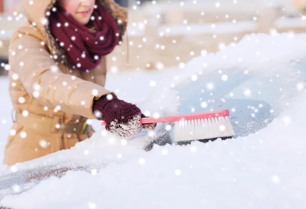 Großaufnahme einer Frau, die Schnee von Auto reinigt — Stockfoto