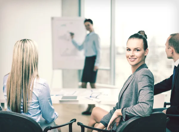 Empresaria con equipo mostrando en oficina — Foto de Stock