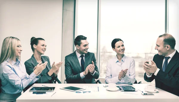 Business-Team mit Laptop klatscht in die Hände — Stockfoto