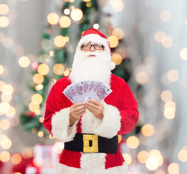 Man in kostuum van de kerstman met euro geld — Stockfoto