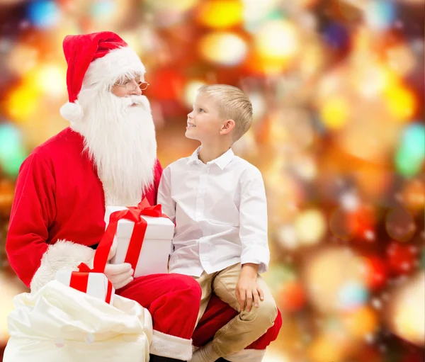 Усміхнений маленький хлопчик з Сантою Клаус і подарунками — стокове фото