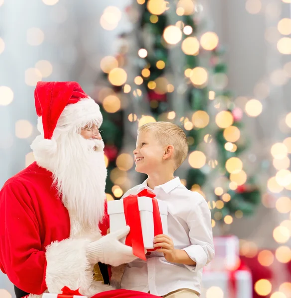 Lächelnder kleiner Junge mit Weihnachtsmann und Geschenken — Stockfoto