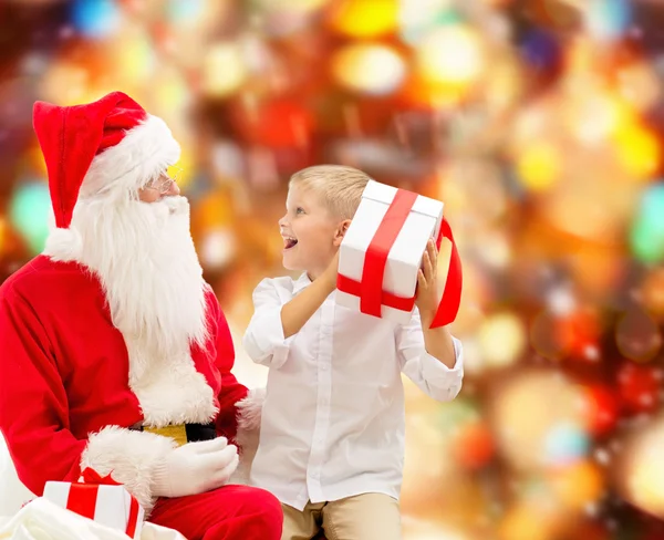 Lachende jongetje met santa claus en giften — Stockfoto